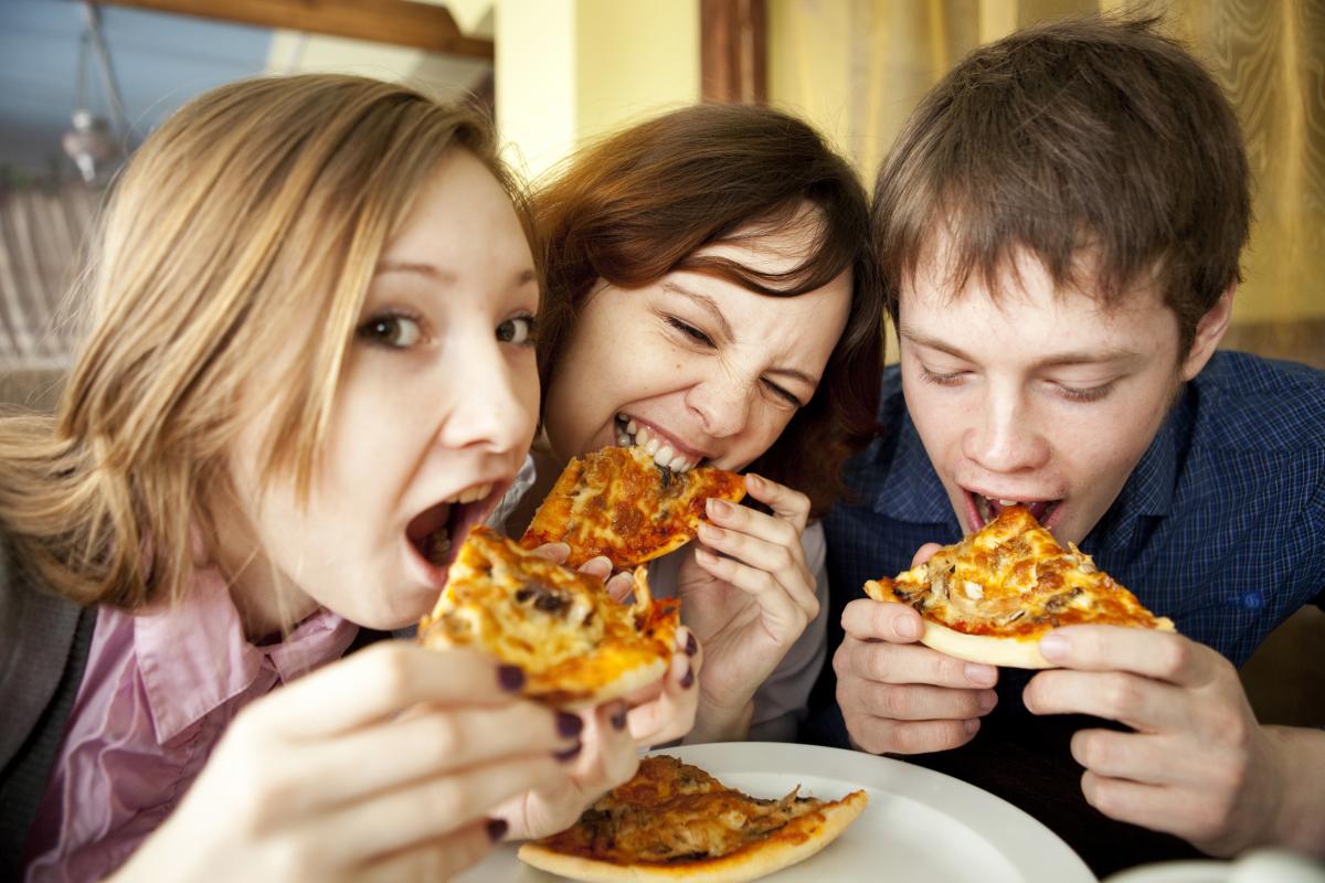 Jeunes mangeant de la pizza - crédit Shutterstock EduardSV